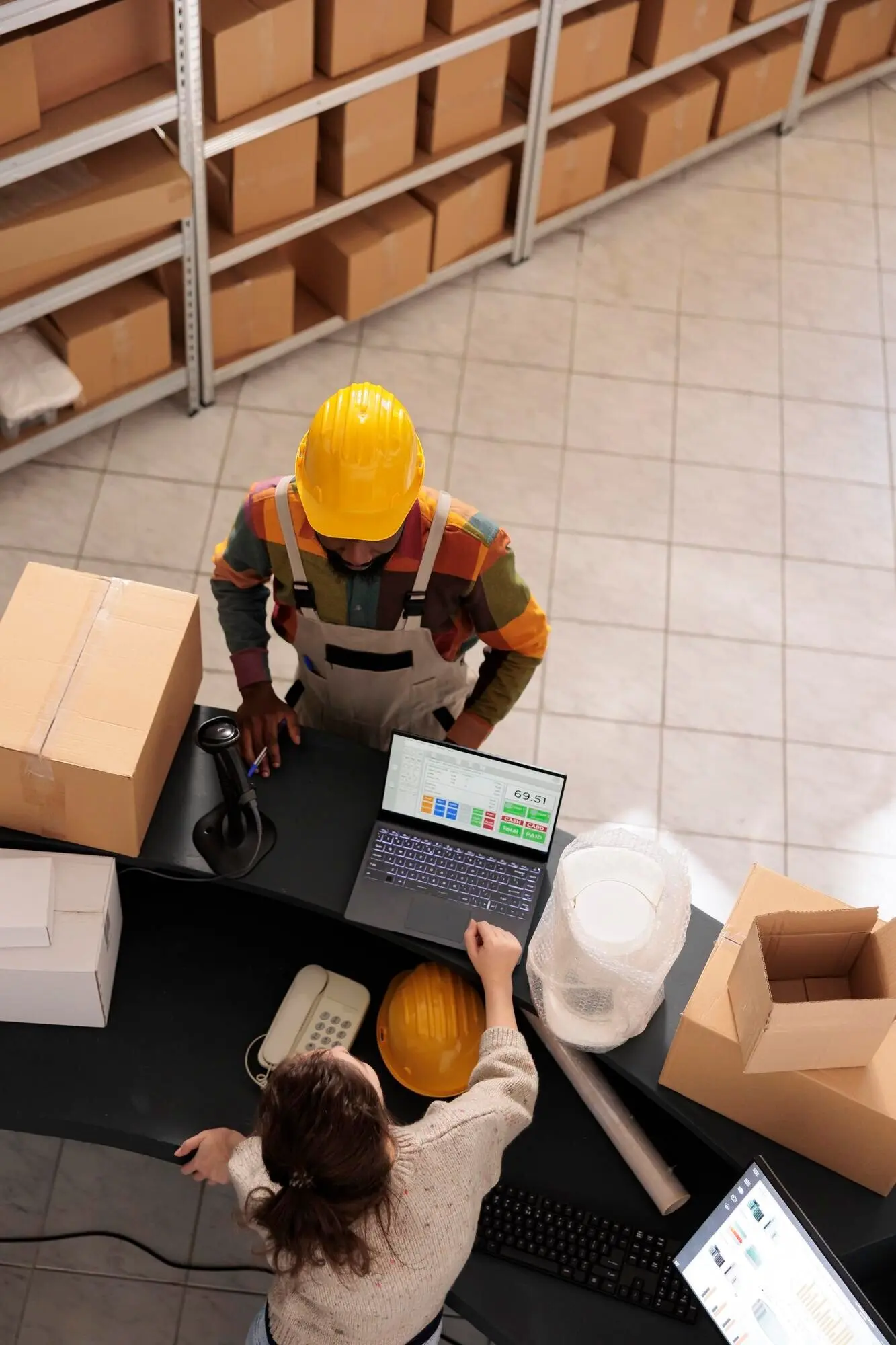 Ansicht von oben auf ein vielfältiges Team, das eine Kundenbestellung bespricht.